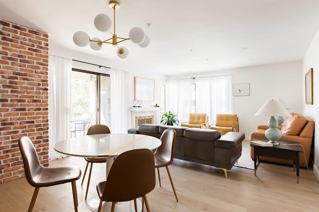 5645 Friars Rd Unit 370, San Diego, CA 92110 - dining space with light wood-style floors, a chandelier, and a fireplace