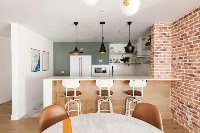 5645 Friars Rd Unit 370, San Diego, CA 92110 - kitchen with high quality fridge, wall chimney exhaust hood, light wood-style flooring, white microwave, and a kitchen breakfast bar