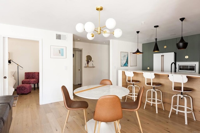 5645 Friars Rd Unit 370, San Diego, CA 92110 - dining space with light wood-type flooring and a chandelier