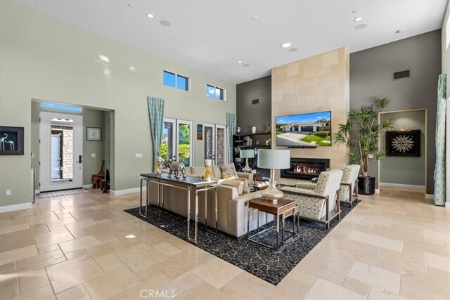 17 Emerald Ct, Rancho Mirage, CA 92270 - living room with a high ceiling, stone tile flooring, recessed lighting, an accent wall, and a large fireplace