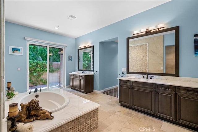 17 Emerald Ct, Rancho Mirage, CA 92270 - full bathroom featuring two vanities, a garden tub, and healthy amount of natural light