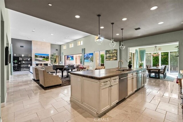 17 Emerald Ct, Rancho Mirage, CA 92270 - kitchen featuring stainless steel dishwasher, dark countertops, recessed lighting, stone tile flooring, and a center island with sink
