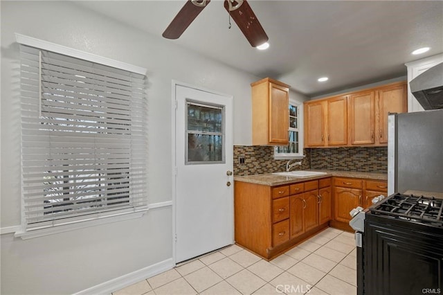 15702 Halldale Ave, Gardena, CA 90247 - kitchen featuring freestanding refrigerator, gas range oven, a ceiling fan, backsplash, and light countertops