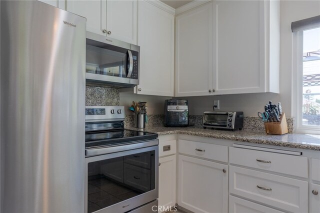 2247 Stratford Way, La Verne, CA 91750 - kitchen featuring appliances with stainless steel finishes, white cabinets, and light stone counters