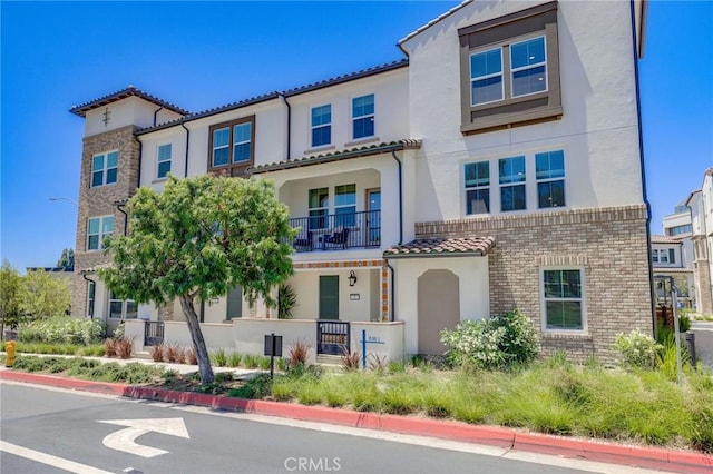 15218 Janine Dr Unit 2, Whittier, CA 90605 - view of front facade with stucco siding, a balcony, a tile roof, and brick siding