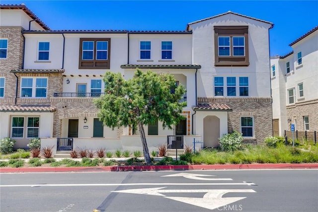 15218 Janine Dr Unit 2, Whittier, CA 90605 - view of property with stucco siding, a tiled roof, and brick siding