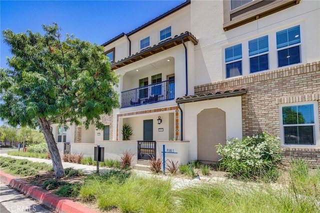 15218 Janine Dr Unit 2, Whittier, CA 90605 - view of front facade featuring a balcony, stucco siding, and brick siding
