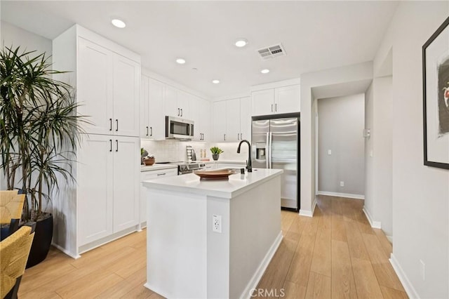 15218 Janine Dr Unit 2, Whittier, CA 90605 - kitchen with stainless steel appliances, light wood-style flooring, light countertops, white cabinetry, and recessed lighting