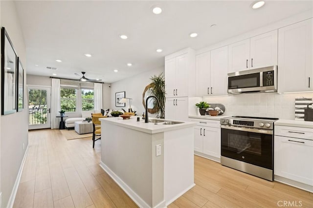 15218 Janine Dr Unit 2, Whittier, CA 90605 - kitchen with stainless steel appliances, light wood-style floors, tasteful backsplash, white cabinetry, and recessed lighting