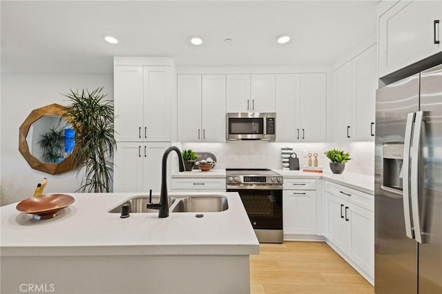 15218 Janine Dr Unit 2, Whittier, CA 90605 - kitchen with appliances with stainless steel finishes, light countertops, white cabinets, backsplash, and light wood-style flooring