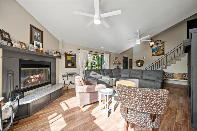 30451 San Pasqual Rd, Temecula, CA 92591 - living area with vaulted ceiling, ceiling fan, light wood-style flooring, a glass covered fireplace, and stairs