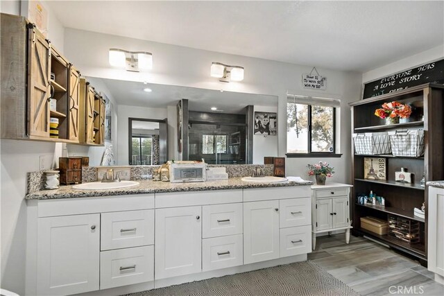 30451 San Pasqual Rd, Temecula, CA 92591 - bathroom with double vanity, a stall shower, wood finished floors, and healthy amount of natural light