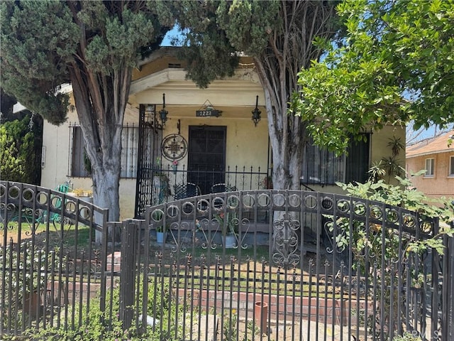 7223 Holmes Ave, Los Angeles, CA 90001 - view of front of house featuring stucco siding, a porch, and a gate