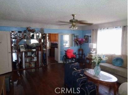 7223 Holmes Ave, Los Angeles, CA 90001 - living room featuring a textured ceiling, a ceiling fan, and wood finished floors