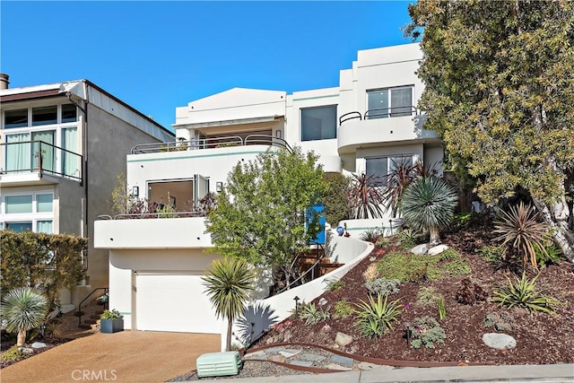 970 Quivera St, Laguna Beach, CA 92651 - art deco home with an attached garage, stucco siding, concrete driveway, and a balcony