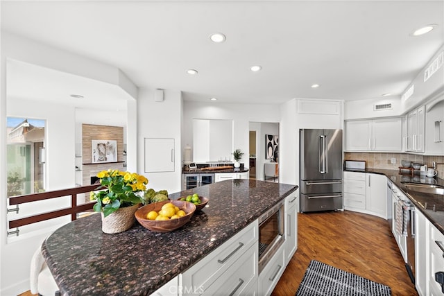970 Quivera St, Laguna Beach, CA 92651 - kitchen with appliances with stainless steel finishes, decorative backsplash, dark wood finished floors, recessed lighting, and dark stone counters