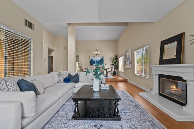 3891 Hunters Grove Ct, Moorpark, CA 93021 - living room featuring a chandelier, wood finished floors, and a glass covered fireplace