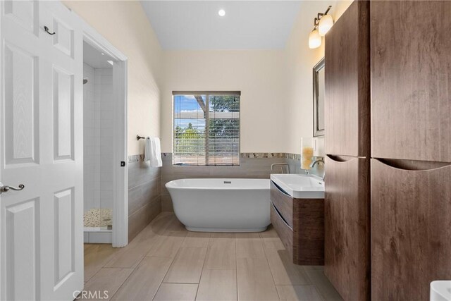3891 Hunters Grove Ct, Moorpark, CA 93021 - bathroom with tile walls, vanity, a freestanding bath, tile patterned floors, and a wainscoted wall