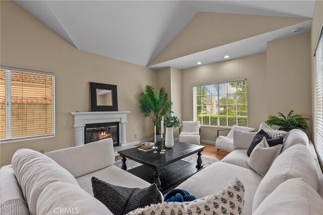 3891 Hunters Grove Ct, Moorpark, CA 93021 - living area featuring lofted ceiling, a glass covered fireplace, recessed lighting, and wood finished floors