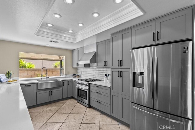 3891 Hunters Grove Ct, Moorpark, CA 93021 - kitchen featuring stainless steel appliances, ornamental molding, gray cabinetry, a tray ceiling, and exhaust hood