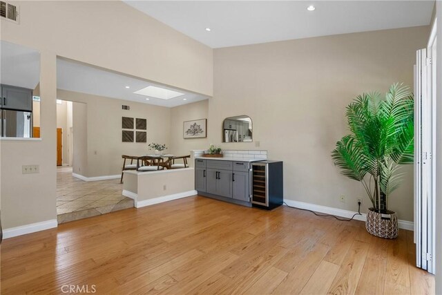 3891 Hunters Grove Ct, Moorpark, CA 93021 - bar area featuring wine cooler, refrigerator, light wood-style flooring, recessed lighting, and a high ceiling