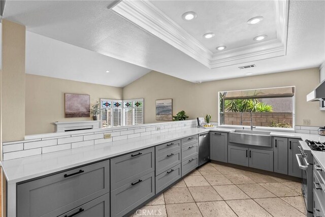 3891 Hunters Grove Ct, Moorpark, CA 93021 - kitchen featuring gray cabinets, appliances with stainless steel finishes, crown molding, a tray ceiling, and light countertops