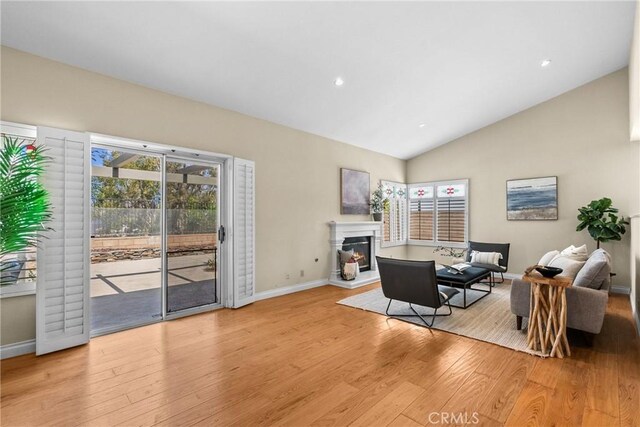 3891 Hunters Grove Ct, Moorpark, CA 93021 - living area with light wood-type flooring, a glass covered fireplace, lofted ceiling, and recessed lighting