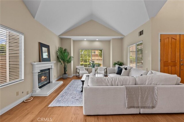 3891 Hunters Grove Ct, Moorpark, CA 93021 - living area featuring vaulted ceiling, wood finished floors, and a glass covered fireplace