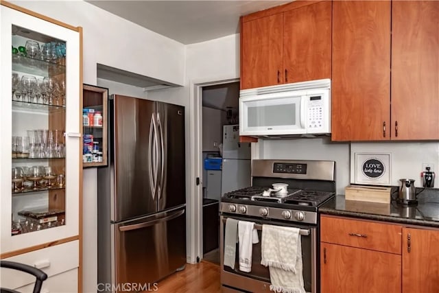 616 E Lomita Ave, Glendale, CA 91205 - kitchen with stainless steel appliances, dark stone counters, light wood-style floors, and brown cabinetry