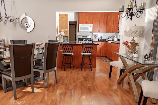 616 E Lomita Ave, Glendale, CA 91205 - kitchen with white microwave, a chandelier, stainless steel range, and brown cabinetry