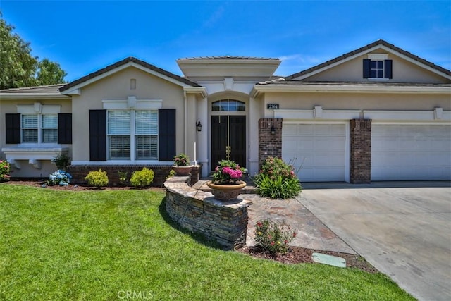 2564 Lunes Ln, Verne, CA 91750 - view of front facade featuring a front yard, concrete driveway, an attached garage, brick siding, and stucco siding