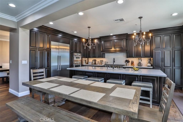 2564 Lunes Ln, Verne, CA 91750 - kitchen featuring a chandelier, appliances with stainless steel finishes, ornamental molding, light countertops, and dark wood-style floors