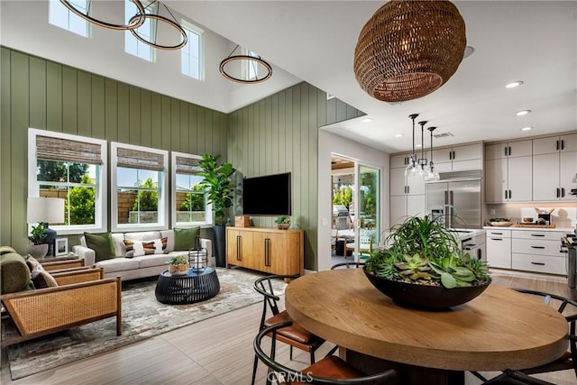 729 Oliver Ave, Placentia, CA 92870 - dining area with light wood-style flooring, a towering ceiling, recessed lighting, wooden walls, and a chandelier