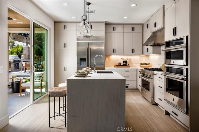 729 Oliver Ave, Placentia, CA 92870 - kitchen with high quality appliances, under cabinet range hood, recessed lighting, hanging light fixtures, and tasteful backsplash