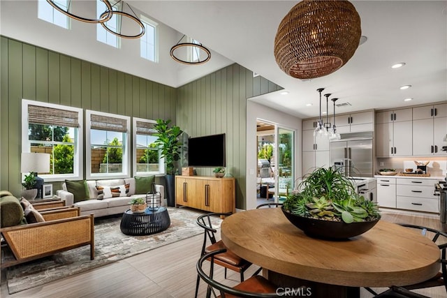 729 Oliver Ave, Placentia, CA 92870 - dining space with a high ceiling, light wood-style floors, recessed lighting, wood walls, and a chandelier