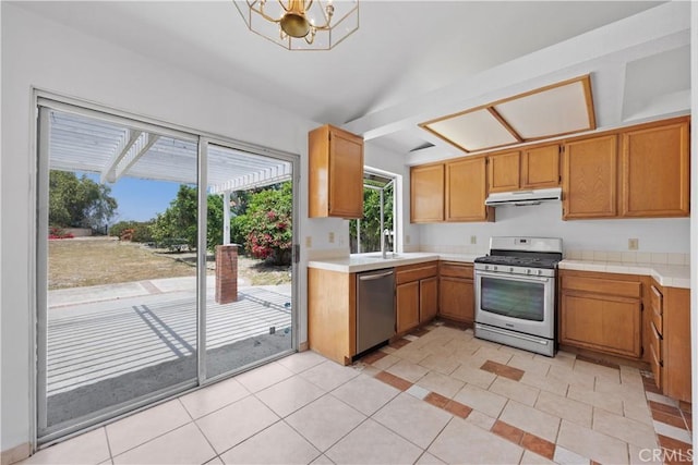 4706 Crestmont Pl, Oceanside, CA 92056 - kitchen featuring appliances with stainless steel finishes, under cabinet range hood, light countertops, a chandelier, and brown cabinets