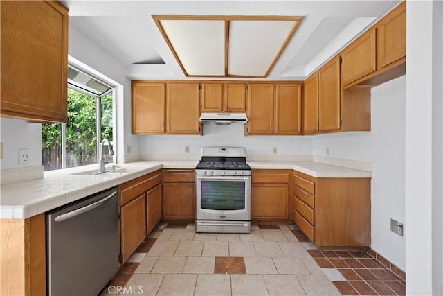 4706 Crestmont Pl, Oceanside, CA 92056 - kitchen featuring appliances with stainless steel finishes, under cabinet range hood, brown cabinets, and light tile patterned floors