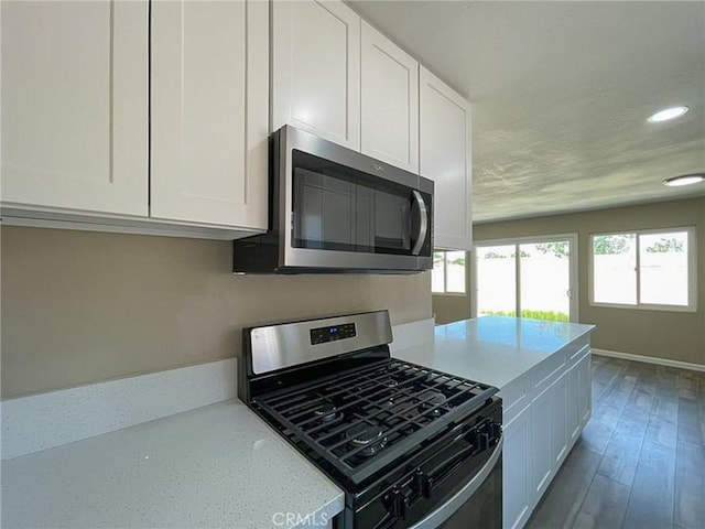 45541 Sancroft Ave, Lancaster, CA 93535 - kitchen featuring appliances with stainless steel finishes, white cabinetry, recessed lighting, light stone countertops, and wood finished floors