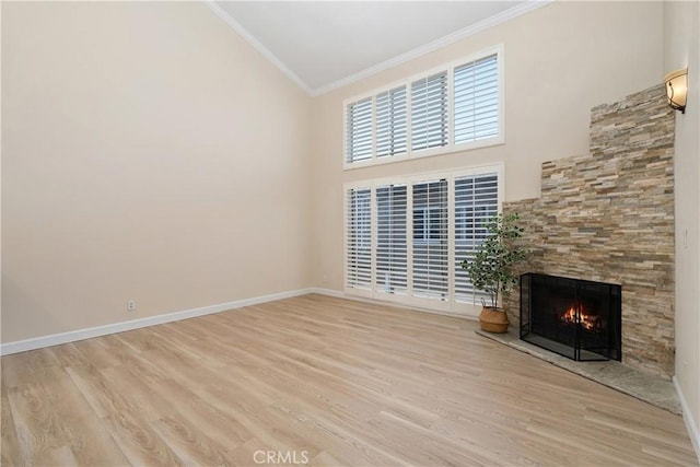14853 Hartsook St Unit 106, Sherman Oaks, CA 91403 - unfurnished living room with crown molding, light wood-style floors, a lit fireplace, and a high ceiling