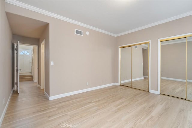 14853 Hartsook St Unit 106, Sherman Oaks, CA 91403 - unfurnished bedroom featuring two closets, light wood finished floors, and ornamental molding