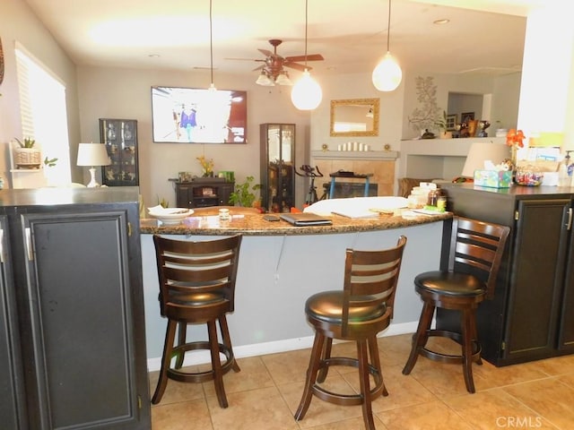 10947 Mesa Linda St, Victorville, CA 92392 - kitchen with ceiling fan, stone countertops, a breakfast bar, and light tile patterned flooring