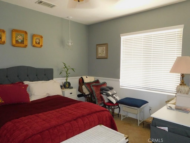 10947 Mesa Linda St, Victorville, CA 92392 - carpeted bedroom featuring multiple windows, wainscoting, and a ceiling fan