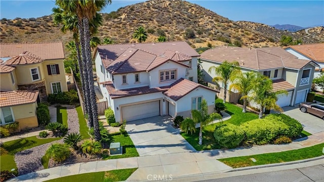 31868 Birchwood Dr, Lake Elsinore, CA 92532 - view of front of house featuring concrete driveway, a garage, a mountain view, and stucco siding