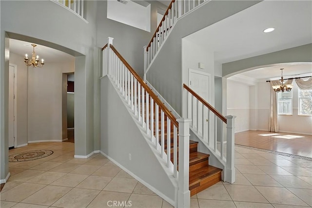 31868 Birchwood Dr, Lake Elsinore, CA 92532 - stairs with a chandelier, tile patterned flooring, a towering ceiling, and arched walkways