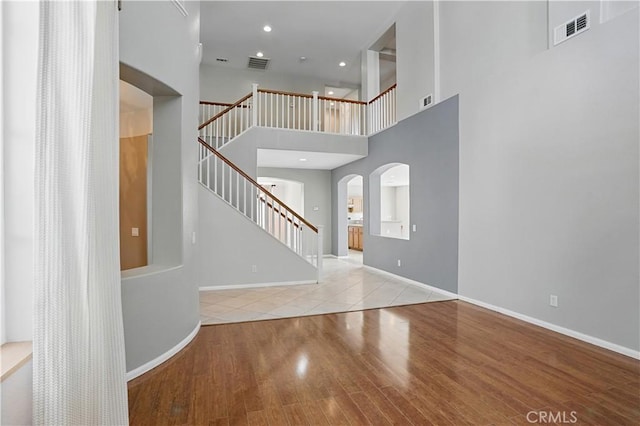 31868 Birchwood Dr, Lake Elsinore, CA 92532 - entryway featuring arched walkways, stairs, wood finished floors, and a towering ceiling