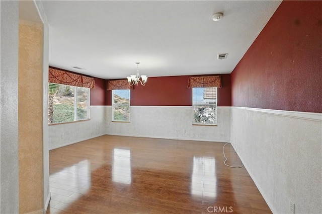 31868 Birchwood Dr, Lake Elsinore, CA 92532 - spare room with wood finished floors, a chandelier, a textured wall, a wainscoted wall, and a smoke detector