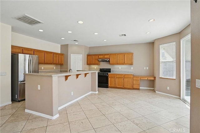 31868 Birchwood Dr, Lake Elsinore, CA 92532 - kitchen with black range with gas cooktop, freestanding refrigerator, under cabinet range hood, light countertops, and recessed lighting