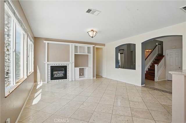 31868 Birchwood Dr, Lake Elsinore, CA 92532 - unfurnished living room featuring plenty of natural light, light tile patterned floors, a tile fireplace, and stairway