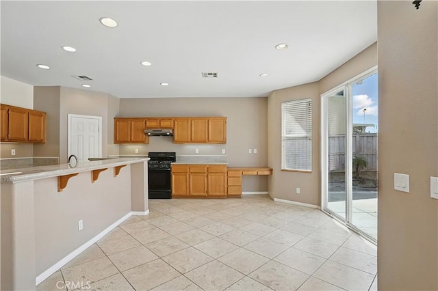 31868 Birchwood Dr, Lake Elsinore, CA 92532 - kitchen featuring under cabinet range hood, black range with gas stovetop, light countertops, a kitchen bar, and recessed lighting