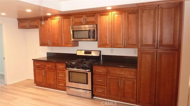 708 N Montebello Blvd, Montebello, CA 90640 - kitchen featuring appliances with stainless steel finishes, brown cabinets, recessed lighting, light wood-type flooring, and dark stone counters